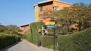 A pathway leading to a hotel with a sign indicating a beach direction. - Cozy Chalet With Stunning View  (Ataqah)
