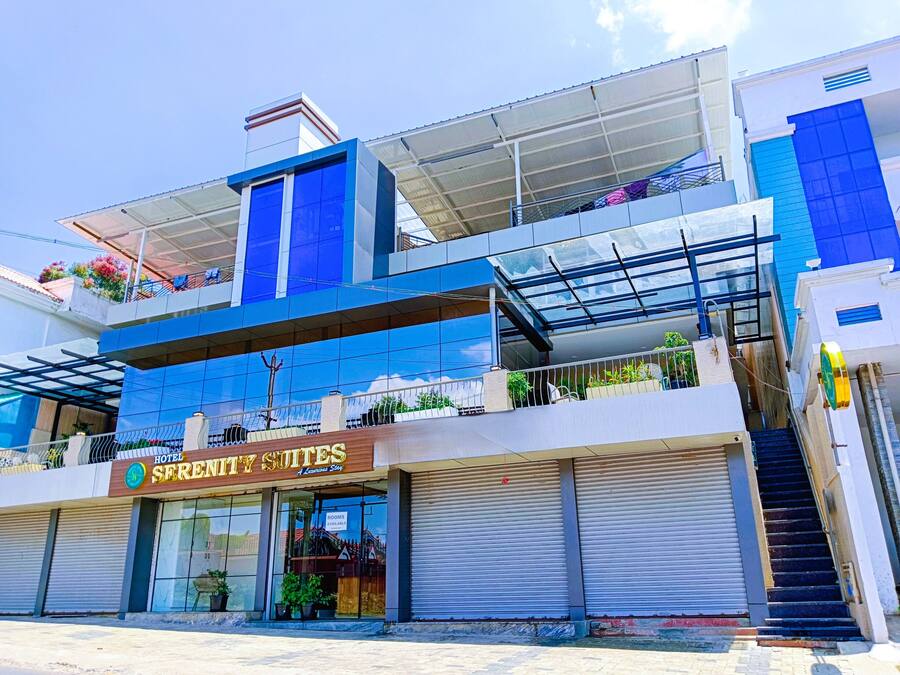 A hotel with a modern design, featuring a prominent sign for 'Hotel Serenity Suites'.