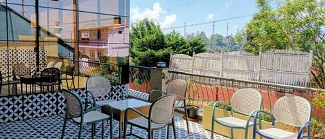 Une terrasse dotée d’un sol à motifs, de sièges d’extérieur et offrant une vue sur un quartier résidentiel.