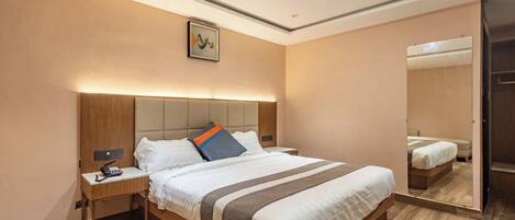 Ein modernes Hotelzimmer mit einem großen Bett, Nachttischen, einem Spiegel und einer Deckenleuchte.