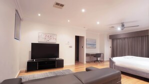 A modern hotel room with a flat-screen TV, a bed, a desk, and a seating area. - Spacious 3 BDR family home with Parking and BBQ! (Perth)