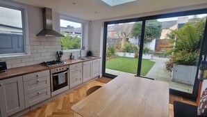 A modern kitchen with a large window, a built-in oven, and a wooden countertop.
