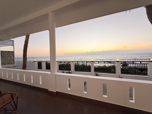 A balcony with a view of the sea at sunset. - Golden Sands Cherai (Kochi)