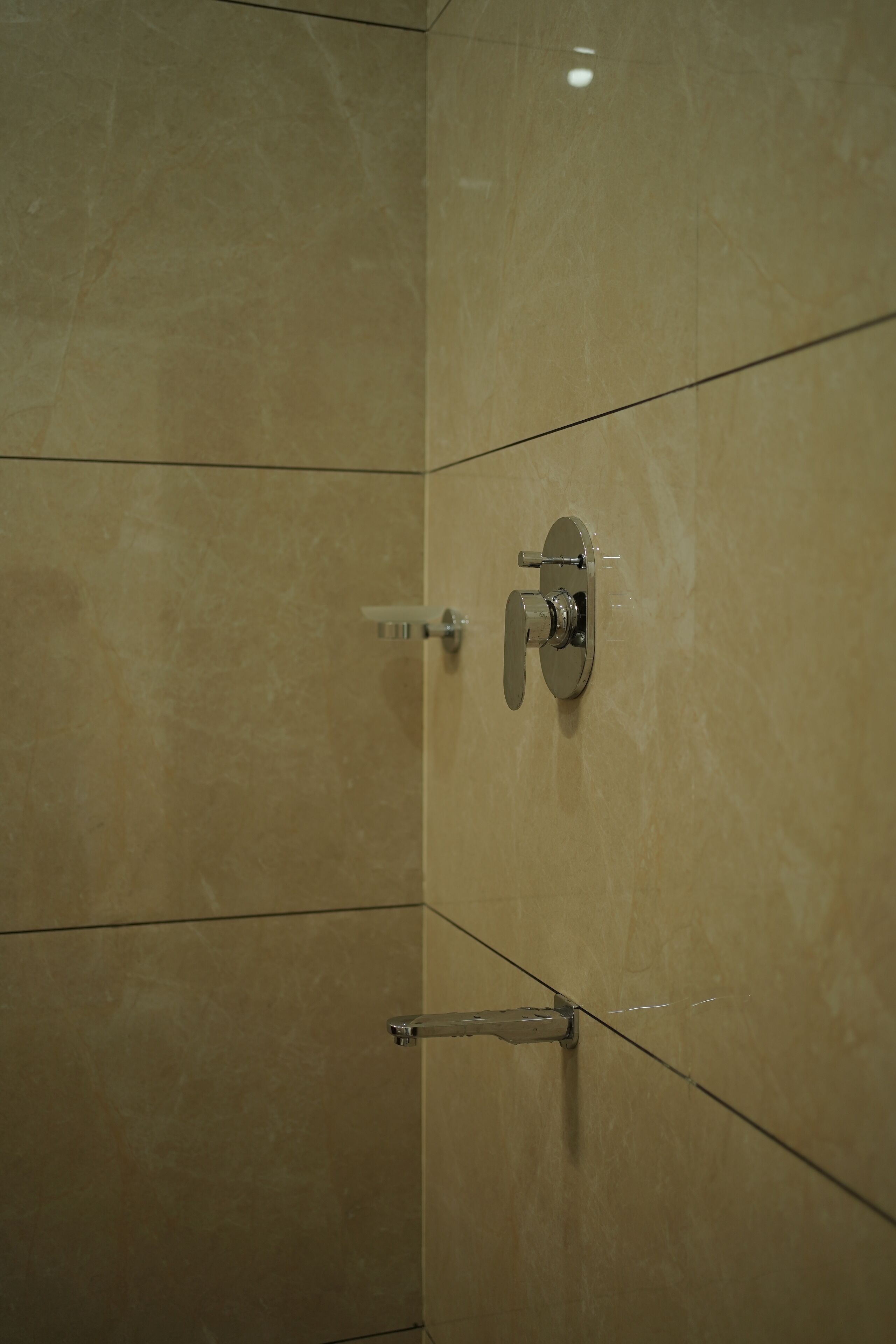 A bathroom with a shower, a towel rack, and a mirror.