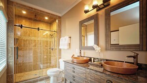 A bathroom with a glass-enclosed shower, a white toilet, a wooden vanity with a round sink, and a large mirror above the vanity. - Charming waterfront hotel in serene Suffolk with WiFi, AC (Suffolk)