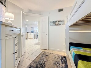 A hallway with a tiled floor, a door leading to a kitchen, and a sign on the wall indicating 'St. Pete Beach'. - Prime Gulf-Front Getaway | Beach Access (St. Pete Beach)