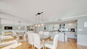 A spacious kitchen with white cabinetry, a central island, and pendant lighting.