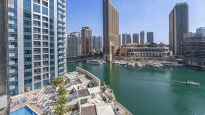 A high-rise hotel with a rooftop pool area and marina views.