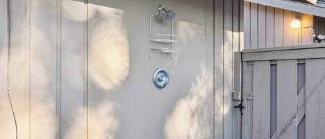 Fachada de edificio con un estante metálico, un accesorio de luz y una puerta.