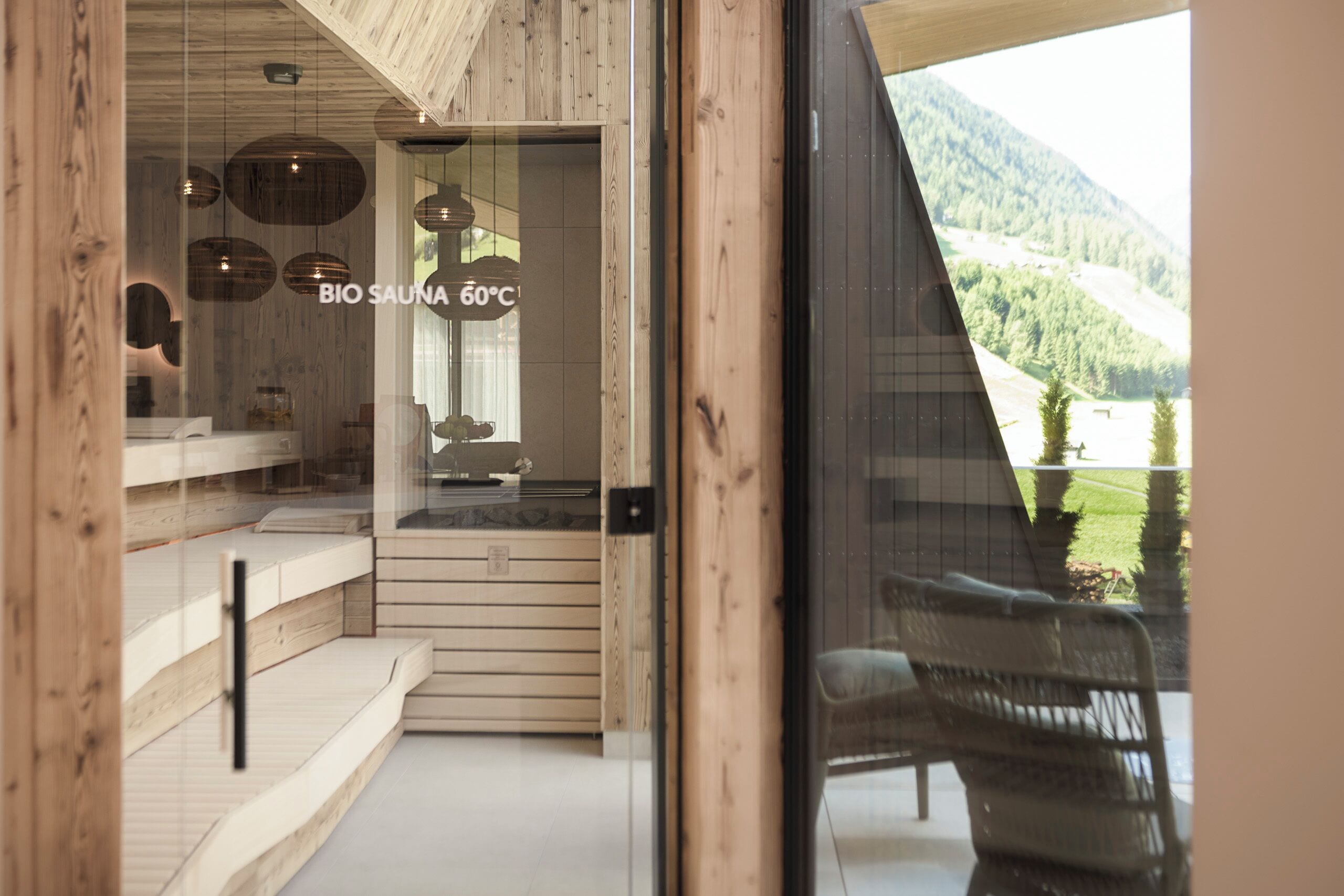 Un centre de bien-être avec un décor intérieur en bois, un comptoir d’accueil et une vue sur un paysage montagneux.