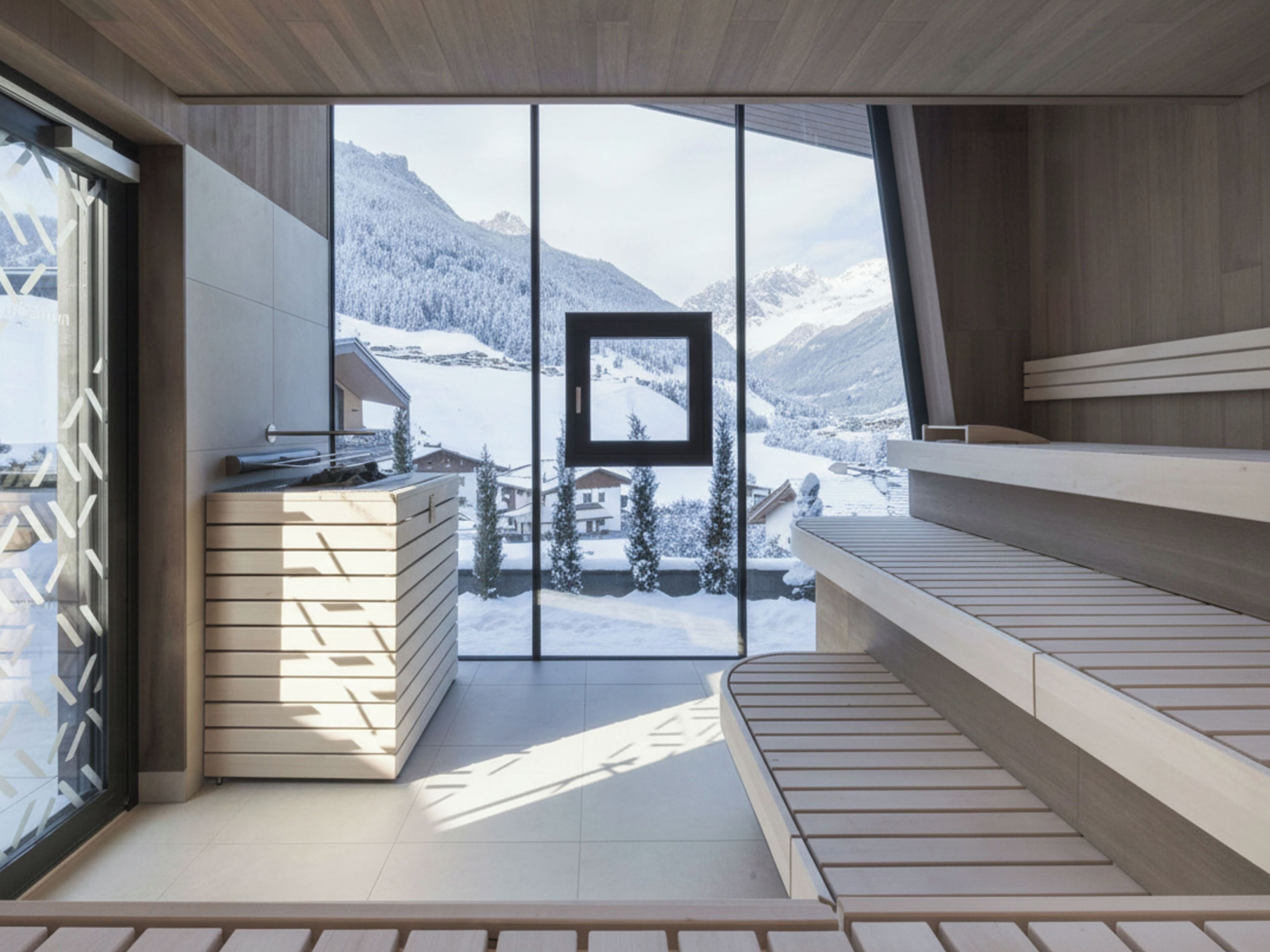 Un sauna moderno con vistas a montañas nevadas.