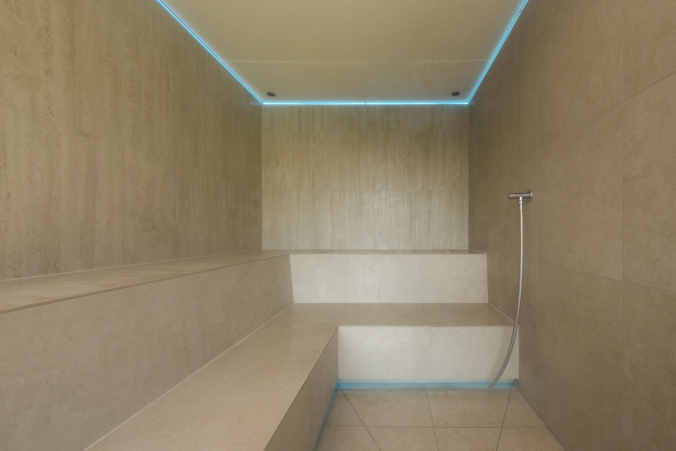 Ein modernes Badezimmer mit minimalistischem Design, das einen Duschbereich mit Glastür und sichtbarer Duschbrause umfasst.