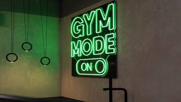Ein Neon-Schild mit der Aufschrift „GYM MODE ON“ in einem schlichten, modernen Raum.