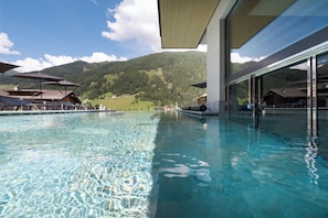 Une piscine intérieure à eau claire, avec une vue sur les montagnes en arrière-plan.
