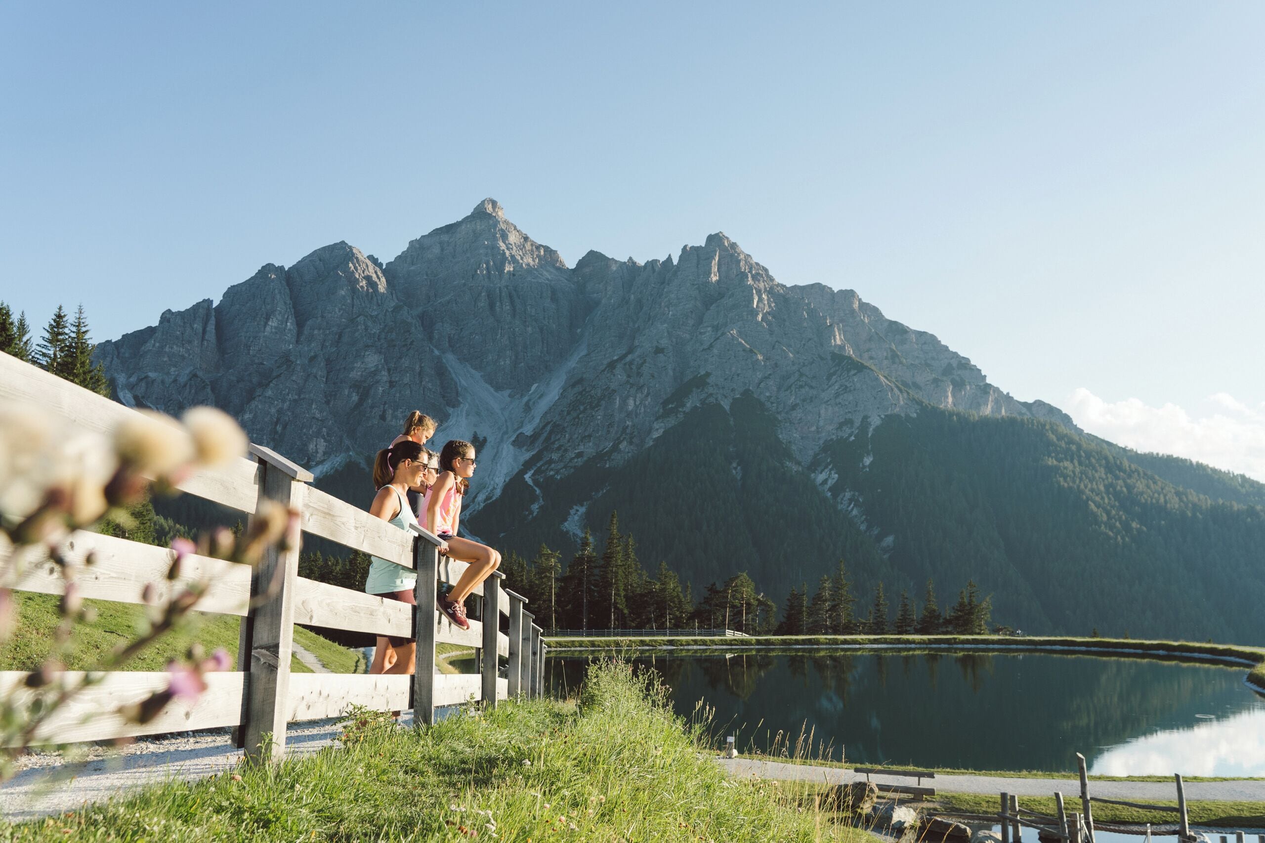 A wooden deck overlooking a lake with mountains in the background.