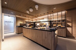 A modern kitchen with wooden cabinetry, a central island, and a glass display case.