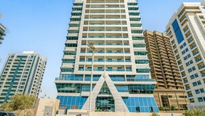 Un moderno edificio de gran altura con varios pisos, ventanas amplias y una característica arquitectónica triangular distintiva en la base.