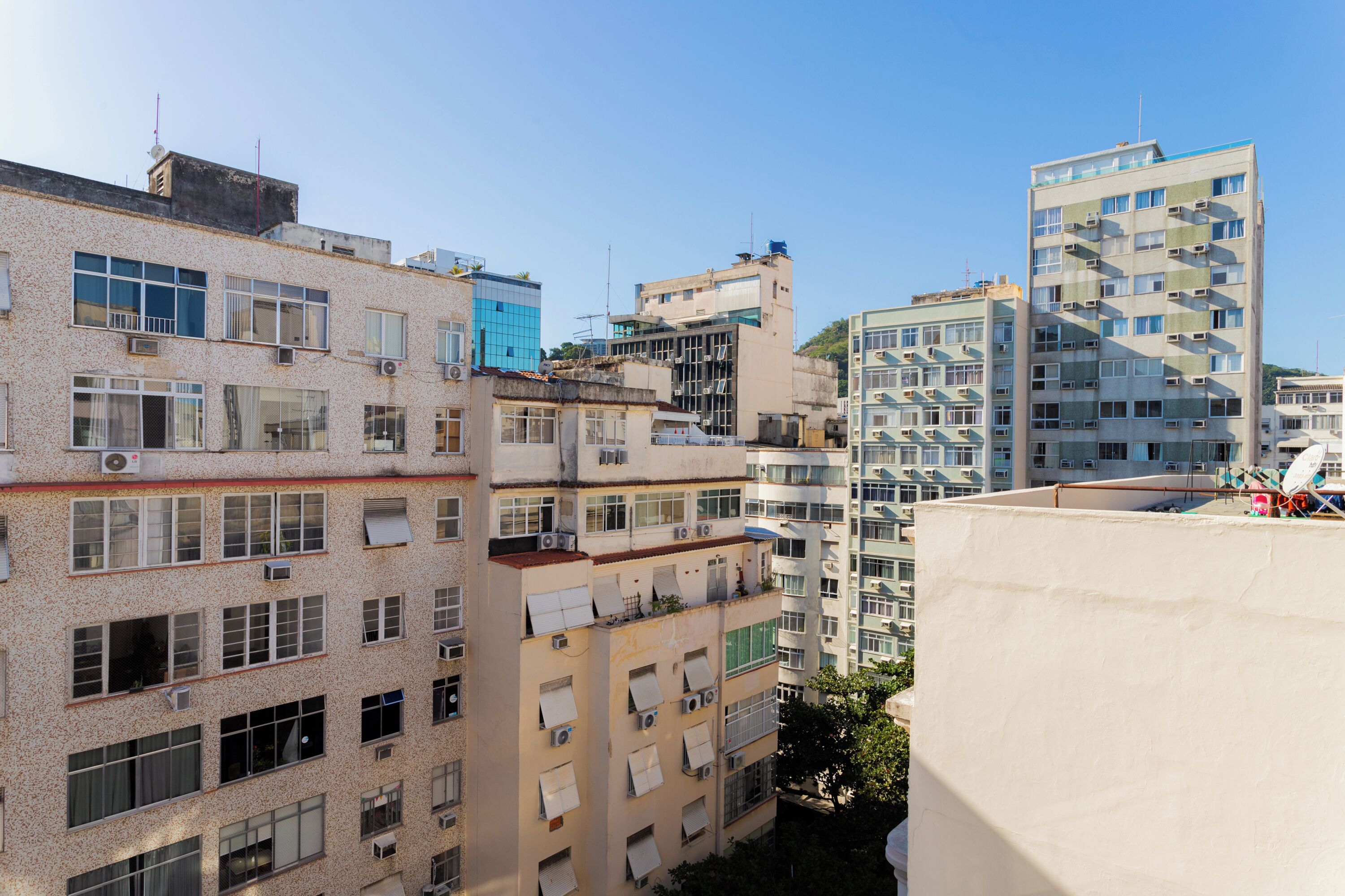 A multi-story residential building with balconies, air conditioning units, and a mix of window styles.