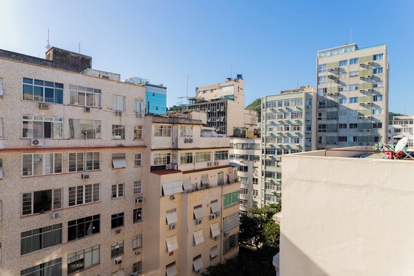 Un edificio residencial de varios pisos con balcones, unidades de aire acondicionado y una variedad de estilos de ventanas.