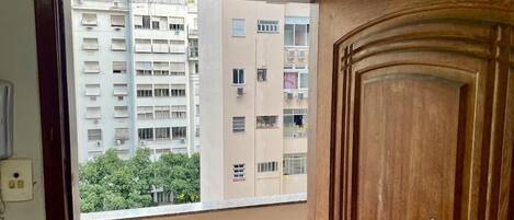 Blick durch ein Fenster, rechts eine Holztür.
