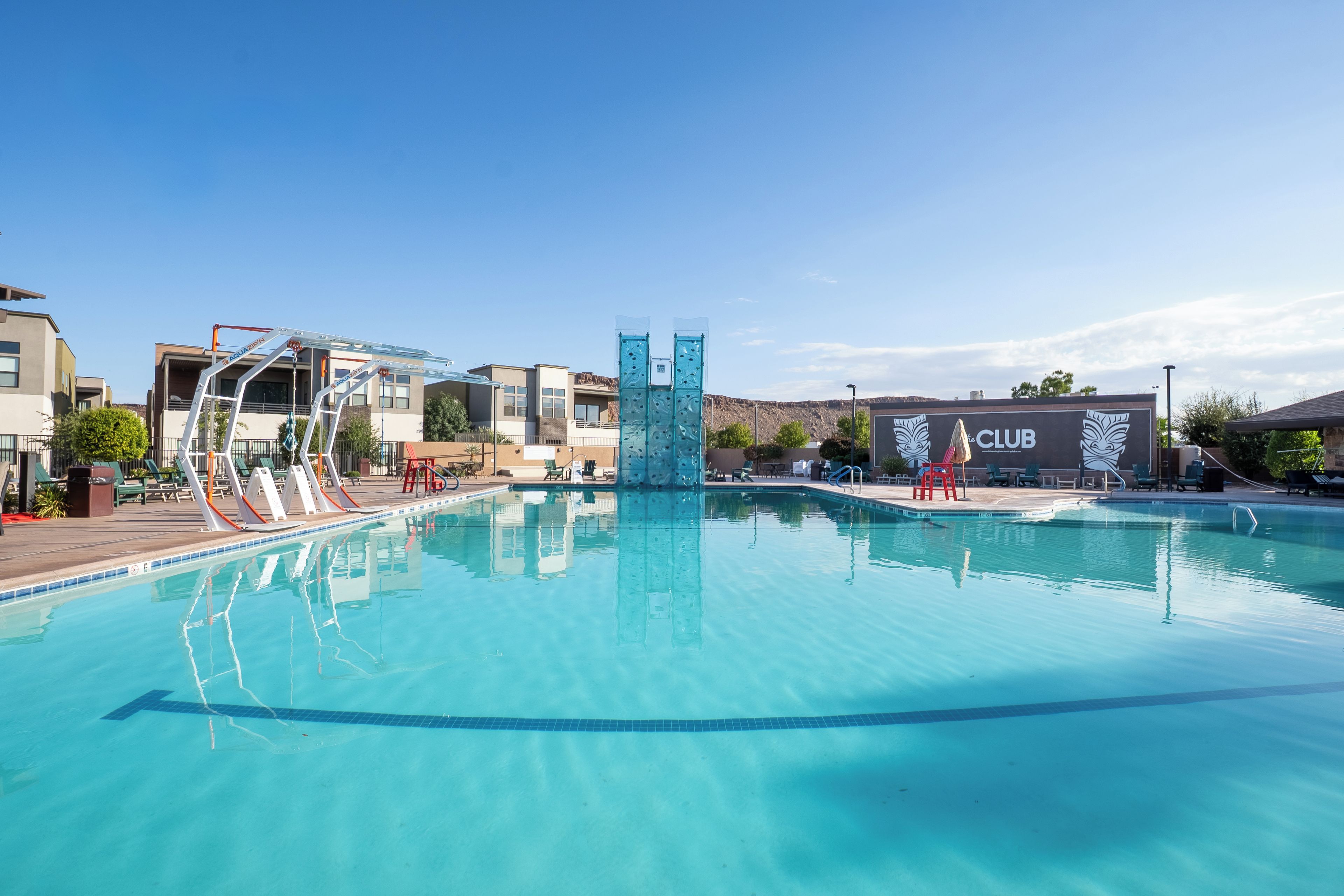 A clear swimming pool with a diving platform and a lifeguard stand.