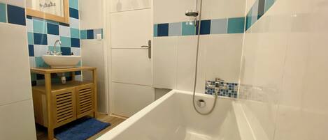 Une salle de bain moderne avec une baignoire, un lavabo et un miroir.