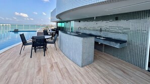 A modern outdoor pool area with a bar and seating. - RN STUDIO APTO 414 (Maceió)