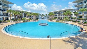 A large circular pool with a central fountain, surrounded by palm trees and lounge chairs. - Adagio G-403 Poolside 3/3 - NEW to program for 2025! (Santa Rosa Beach)