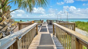 A wooden boardwalk leading to a beach with a clear view of the ocean and palm trees. - Adagio G-403 Poolside 3/3 - NEW to program for 2025! (Santa Rosa Beach)