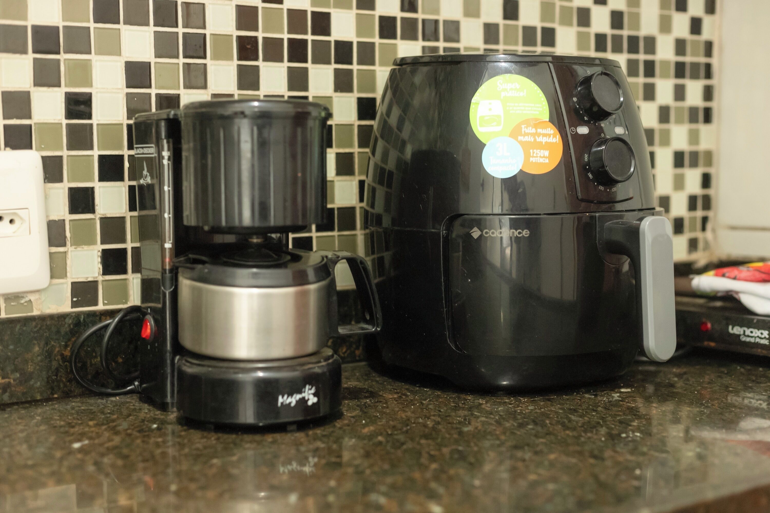 Une machine à café et un cuiseur à riz sont posés sur le plan de travail de la cuisine.