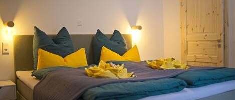 A neatly made bed with a headboard, pillows, and a blanket.