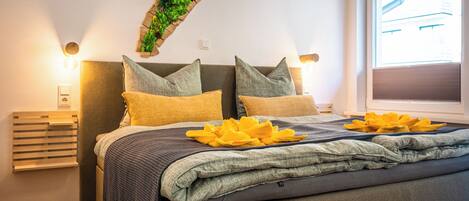 Une chambre à coucher moderne avec un lit, des oreillers et une fenêtre.