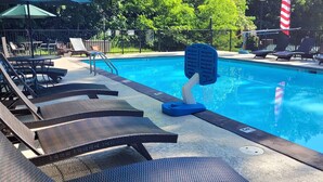 A swimming pool with lounge chairs and a flag. - Sugar Maple Sunset in Shagbark (Sevierville)