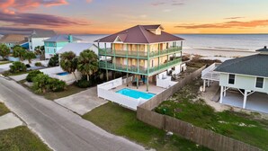 A multi-story beachfront house with a pool, balconies, and a view of the ocean. - Gulf Front Home with Pool | Hot Tub (Port St Joe)