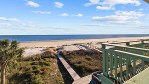 A beach view from a wooden deck with a pathway leading to the shore. - Gulf Front Home with Pool | Hot Tub (Port St Joe)