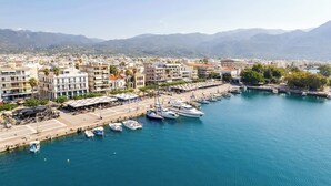 A marina with boats docked, a waterfront promenade, and buildings with balconies overlooking the water. - Beachfront Sunny Penthouse - Kalamata SeaBliss (Kalamata)