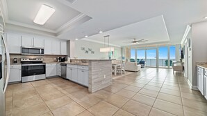 A modern kitchen with white cabinets, stainless steel appliances, and a large island. - New Complex!  Lazy River/Slide, Beachfront! (Orange Beach)
