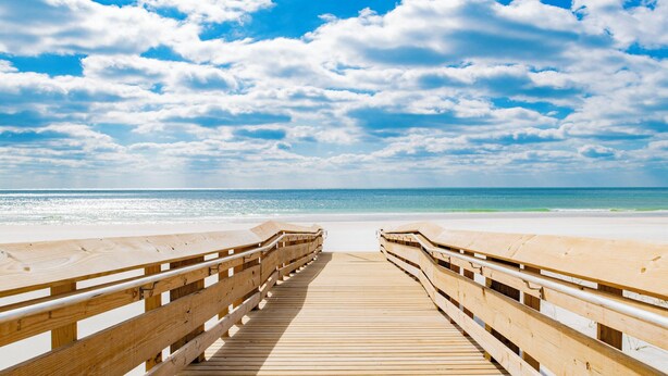 A wooden boardwalk leading to a beach with a clear sky and ocean in the background. - New Complex!  Lazy River/Slide, Beachfront! (Orange Beach)