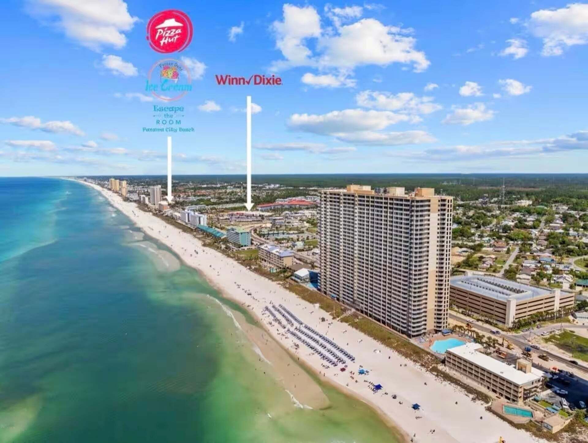 Un paisaje urbano costero con playa, edificios altos y un hotel grande con piscina.