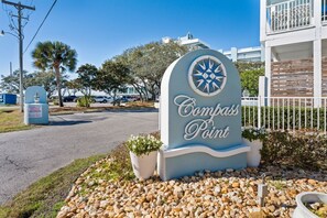 Naamplaatje voor Compass Point hotel met een goed uitzicht op de omgeving, waaronder een parkeerplaats en naburige gebouwen.