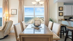 Un comedor con vista a la playa, un candelabro y una zona de cocina.