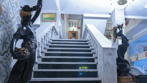 Una imponente escalera con estatuas a ambos lados que conduce a un nivel superior.