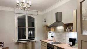 Una cocina con ventana, estufa, lavavajillas y cafetera.