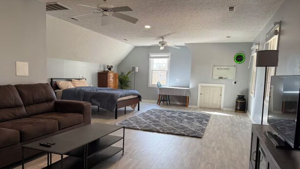 Una sala de estar moderna con sofá, mesa de centro y televisor sobre un mueble.