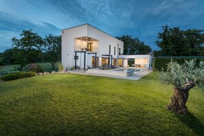 A modern house with a swimming pool, a covered patio, and a well-maintained lawn. - Villa Luce Verde - beautiful villa with private pool, hot tub and sauna near the town of Porec and its beaches (Kirmenjak)
