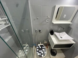 A modern bathroom with a glass shower enclosure, a white sink with a mirror, and a toilet with a black and white patterned seat. - 360 Copa Santa Clara 98 By SUHCasa (Rio de Janeiro)