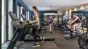 Una palestra con tapis roulant, cyclette e macchinari per l'allenamento con i pesi.