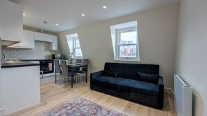 Un appartement moderne comprenant une cuisine, un coin repas et un salon.