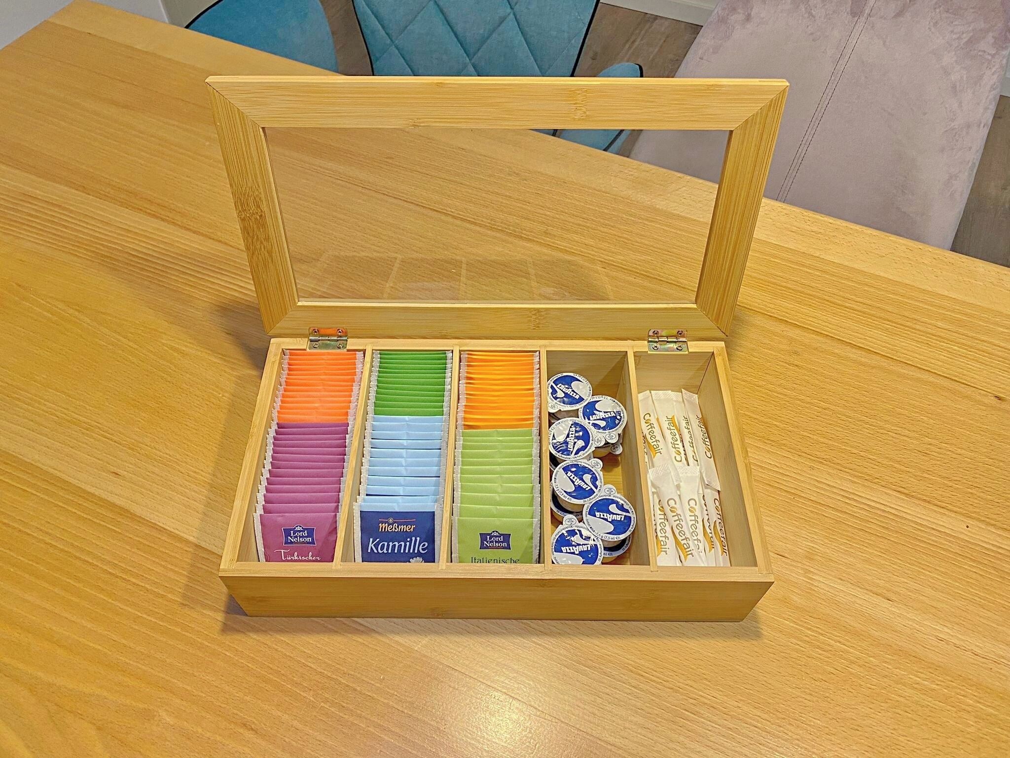 Un cofanetto di legno con scomparti contenenti diverse cialde per caffè.