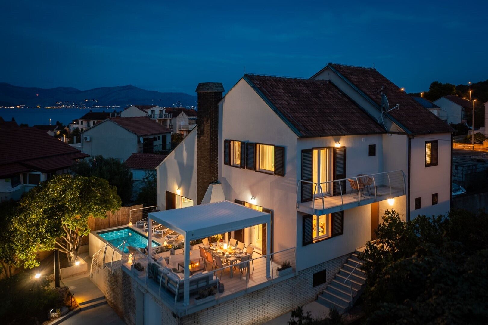 A two-story house with a balcony and a swimming pool.
